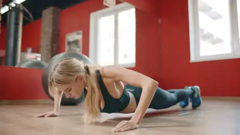 Athlete woman training push up exercise in gym club