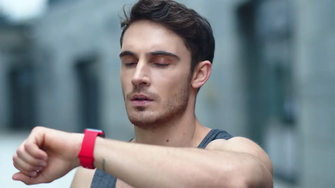 Closeup male athlete using smart clock outside Fit man setting smart watch