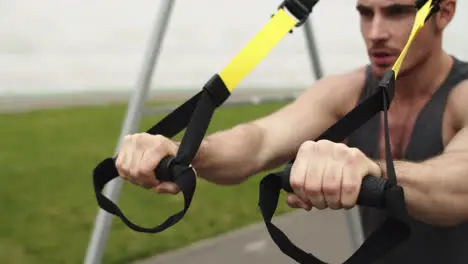 Closeup man working out with trx fitness rope Guy training with suspension rope