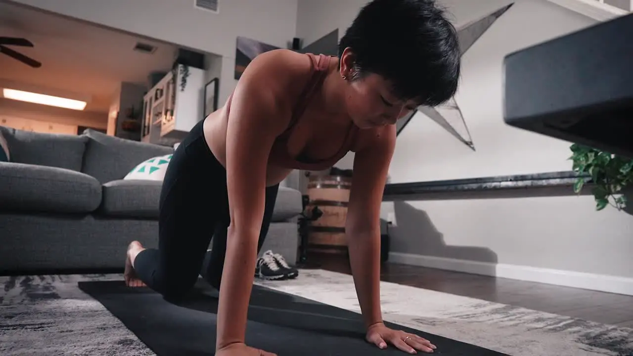 Young asian woman doing yoga stretching in living room downward facing dog vinyasa flow happy during workout slow motion