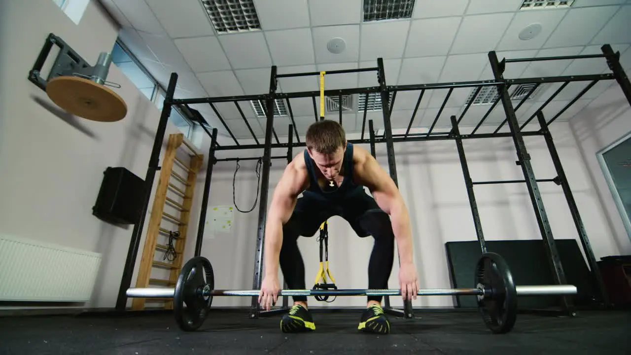 Athlete trains with a barbell in the gym