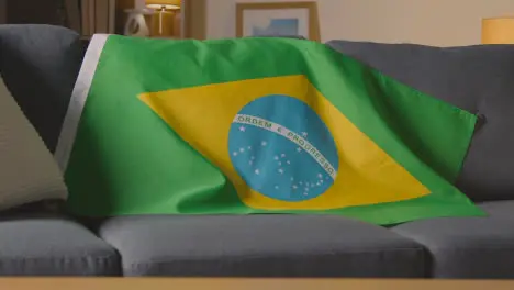 Flag Of Brazil Draped Over Sofa At Home Ready For Match On TV