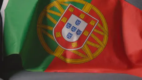 Close Up Of Flag Of Portugal Draped Over Sofa At Home Ready For Match On TV