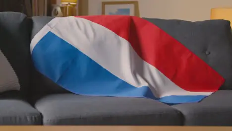 Flag Of Holland Draped Over Sofa At Home With Football Ready For Match On TV 3