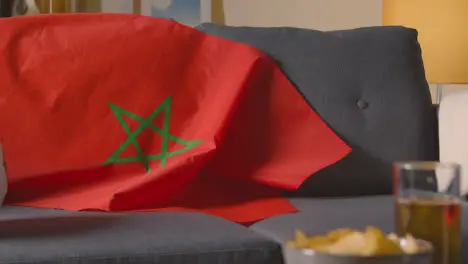 Flag Of Morocco Draped Over Sofa At Home With Football Ready For Match On TV 2