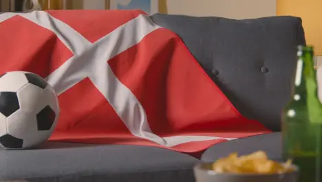 Flag Of Denmark Draped Over Sofa At Home With Football Ready For Match On TV 2