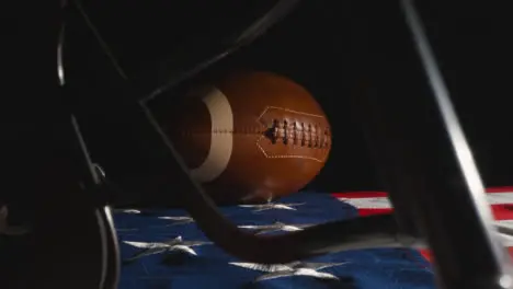 Low Key Lighting Studio Shot Of American Football With Helmet On Stars And Stripes Flag 3