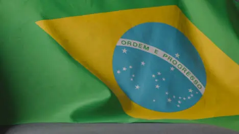 Close Up Of Flag Of Brazil Draped Over Sofa At Home Ready For Match On TV