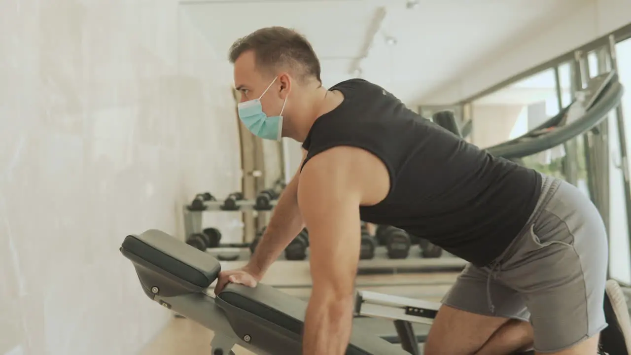 Young Strong Man With Face Mask Lifts Weights And Exercises In The Gym 1