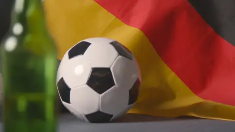 Flag Of Germany Draped Over Sofa At Home With Football Ready For Match On TV 2