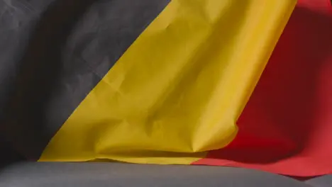 Close Up Of Flag Of Belgium Draped Over Sofa At Home Ready For Match On TV