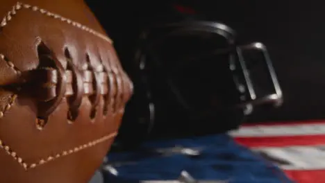 Low Key Lighting Studio Shot Of American Football With Helmet On Stars And Stripes Flag 2