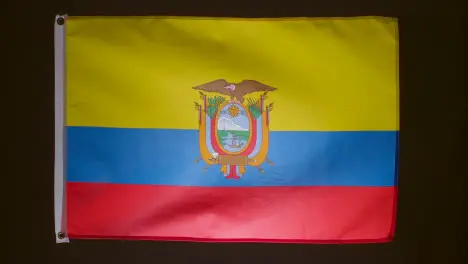 Studio Shot Of Flag Of Ecuador Falling Down Against Black Background