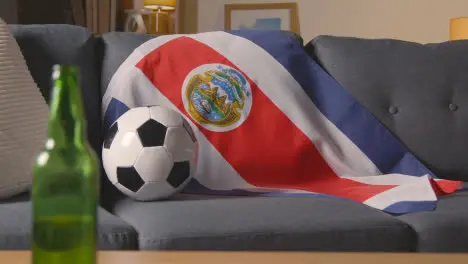 Flag Of Costa Rica Draped Over Sofa At Home With Football Ready For Match On TV 1