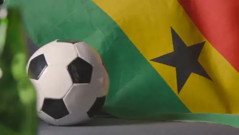 Flag Of Ghana Draped Over Sofa At Home With Football Ready For Match On TV 3