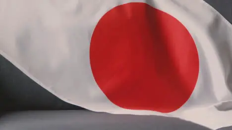 Close Up Of Flag Of Japan Draped Over Sofa At Home Ready For Match On TV