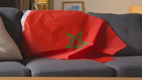 Flag Of Morocco Draped Over Sofa At Home Ready For Match On TV