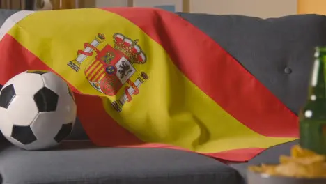 Flag Of Spain Draped Over Sofa At Home With Football Ready For Match On TV 1