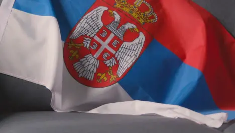 Close Up Of Flag Of Serbia Draped Over Sofa At Home Ready For Match On TV