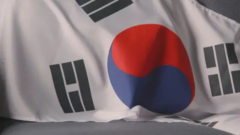 Close Up Of Flag Of South Korea Draped Over Sofa At Home Ready For Match On TV