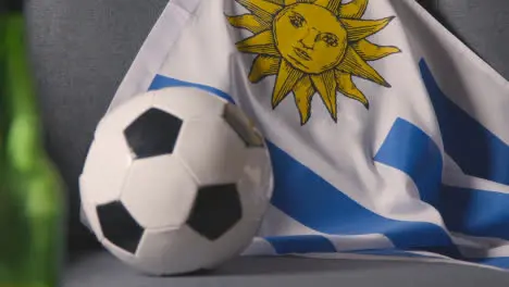 Flag Of Uruguay Draped Over Sofa At Home With Football Ready For Match On TV 2