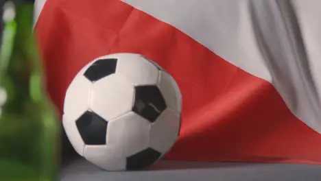 Flag Of Poland Draped Over Sofa At Home With Football Ready For Match On TV 2