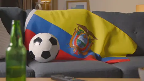 Flag Of Ecuador Draped Over Sofa At Home With Football Ready For Match On TV