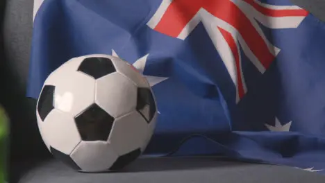 Flag Of Australia Draped Over Sofa At Home With Football Ready For Match On TV 4