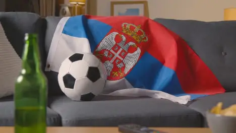 Flag Of Serbia Draped Over Sofa At Home With Football Ready For Match On TV 3