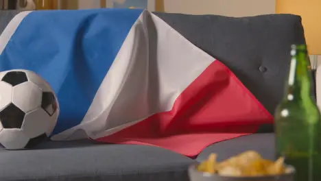 Flag Of France Draped Over Sofa At Home With Football Ready For Match On TV 1