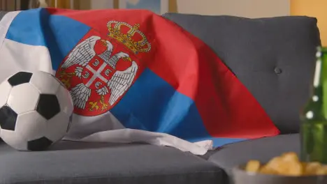 Flag Of Serbia Draped Over Sofa At Home With Football Ready For Match On TV 4