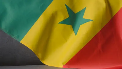 Close Up Of Flag Of Senegal Draped Over Sofa At Home Ready For Match On TV