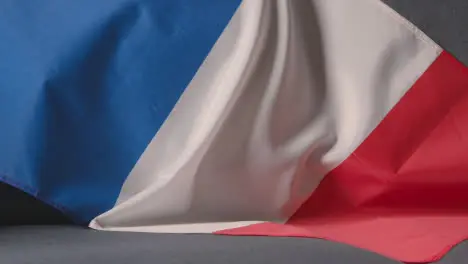 Close Up Of Flag Of France Draped Over Sofa At Home With Football Ready For Match On TV