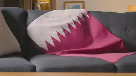 Flag Of Qatar Draped Over Sofa At Home Ready For Match On TV