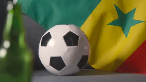 Flag Of Senegal Draped Over Sofa At Home With Football Ready For Match On TV 2