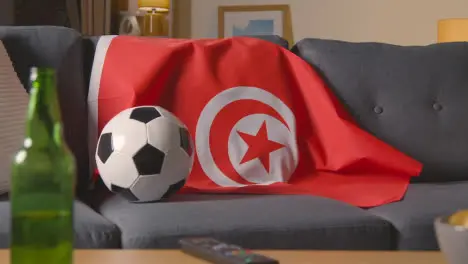 Flag Of Tunisia Draped Over Sofa At Home With Football Ready For Match On TV 1