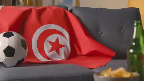 Flag Of Tunisia Draped Over Sofa At Home With Football Ready For Match On TV 2