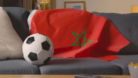 Flag Of Morocco Draped Over Sofa At Home With Football Ready For Match On TV 1