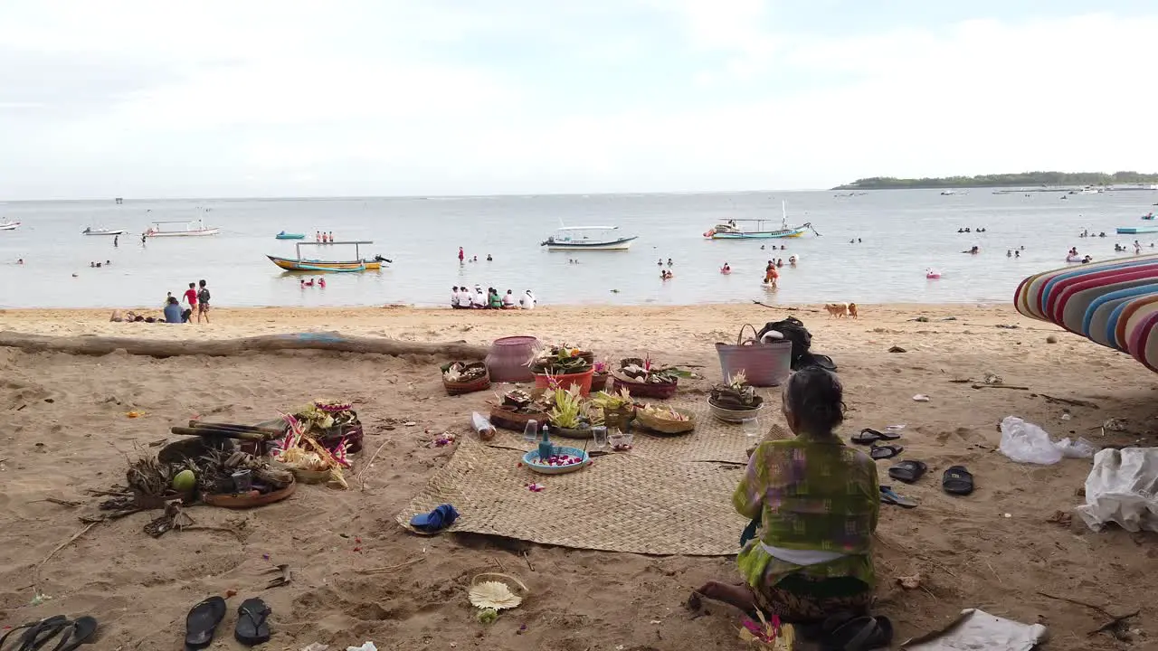 Hindu Woman in Praying Ceremony at Sanur Beach Bali Indonesia Balinese Culture of Hinduism Religion in Open Space with Ornamentes Flowers and Coconut Made Sacred Offerings