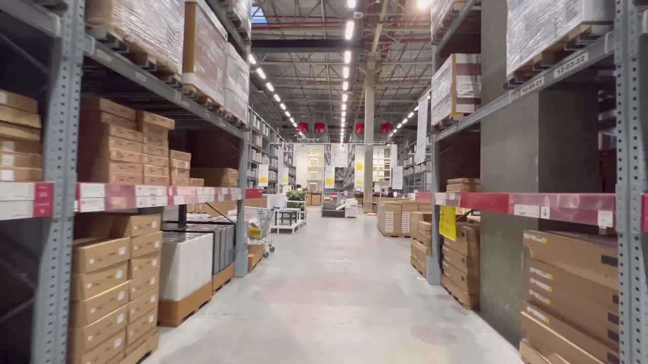 An aisle of a store which have a collection of packed product on both side and as you move forward you will get to main hall of the store