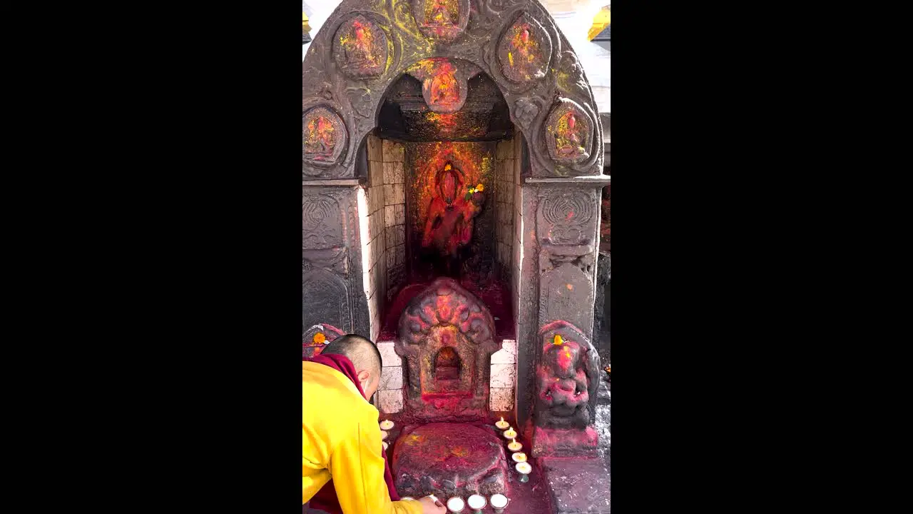 A Buddhist monk lights candles as an offering to the Gods before praying at a Buddhist temple in Nepal