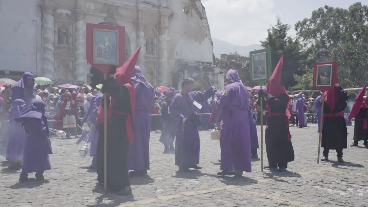 Purple robed Catholic Christian priests cucaruchos perform in the Semana Santa Easter week holidays in Antigua Guatemala 1