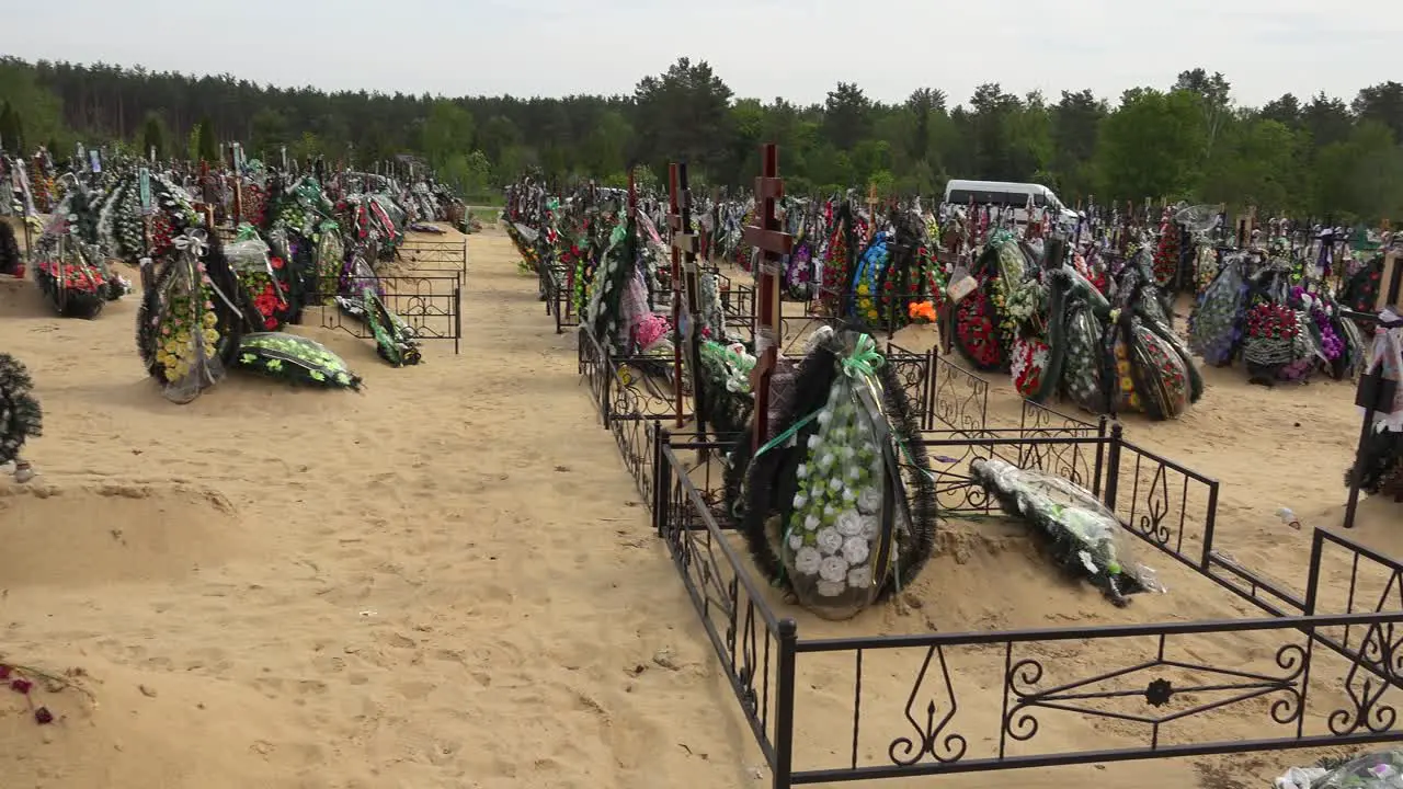 Pan Across Cemetery Reveals A Ukrainian Orthodox Priest Administering Last Rites To A Victim Of The War In Ukraine In The Irpin (Kyiv) Cemetery