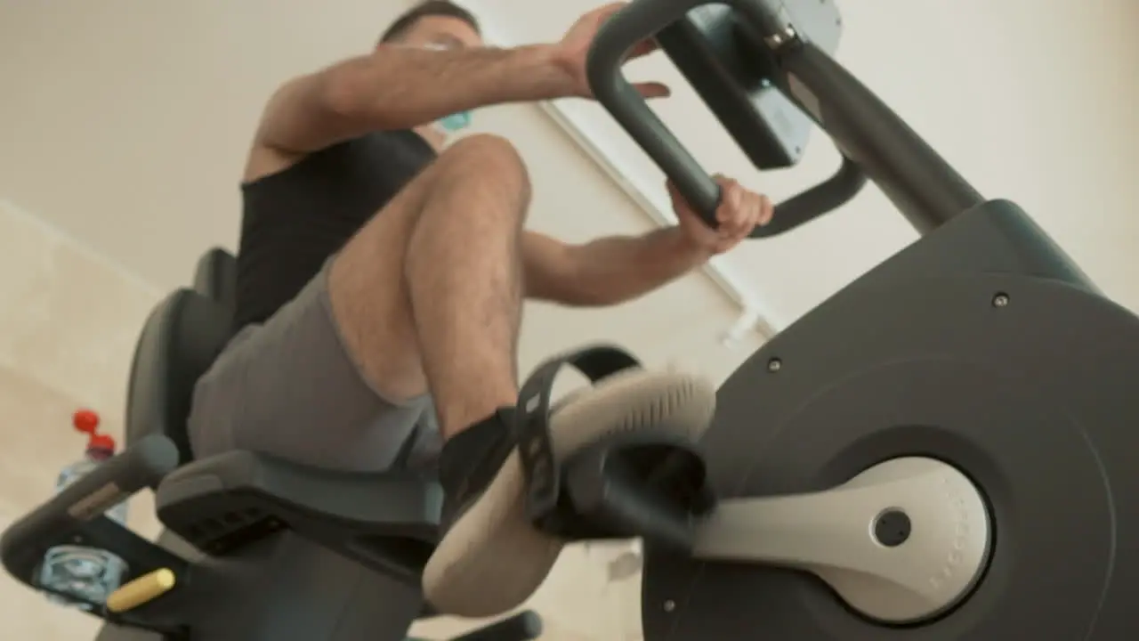 Athlete Male With Face Mask Uses A Stationary Bicycle In The Gym