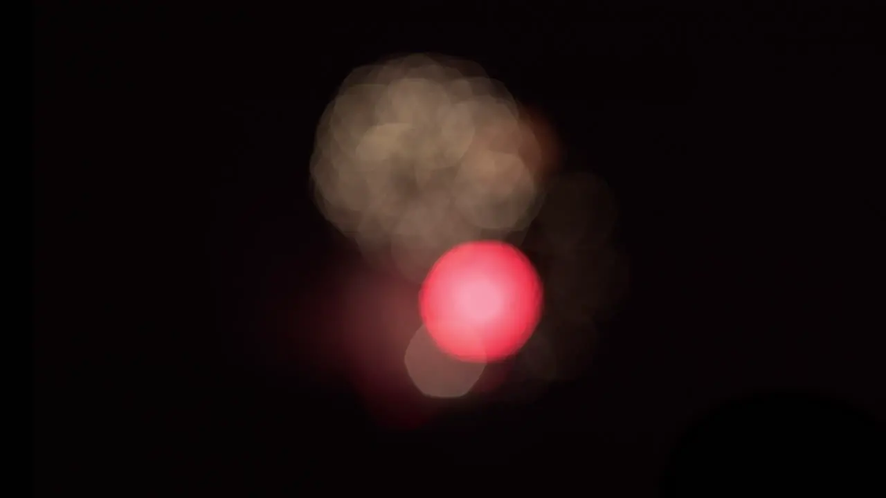 Wide shot of bokeh patterns created by out-of-focus fireworks in the distance