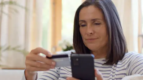 Close Up Shot Revealing Middle Aged Woman Using Smartphone to Make Online Purchase