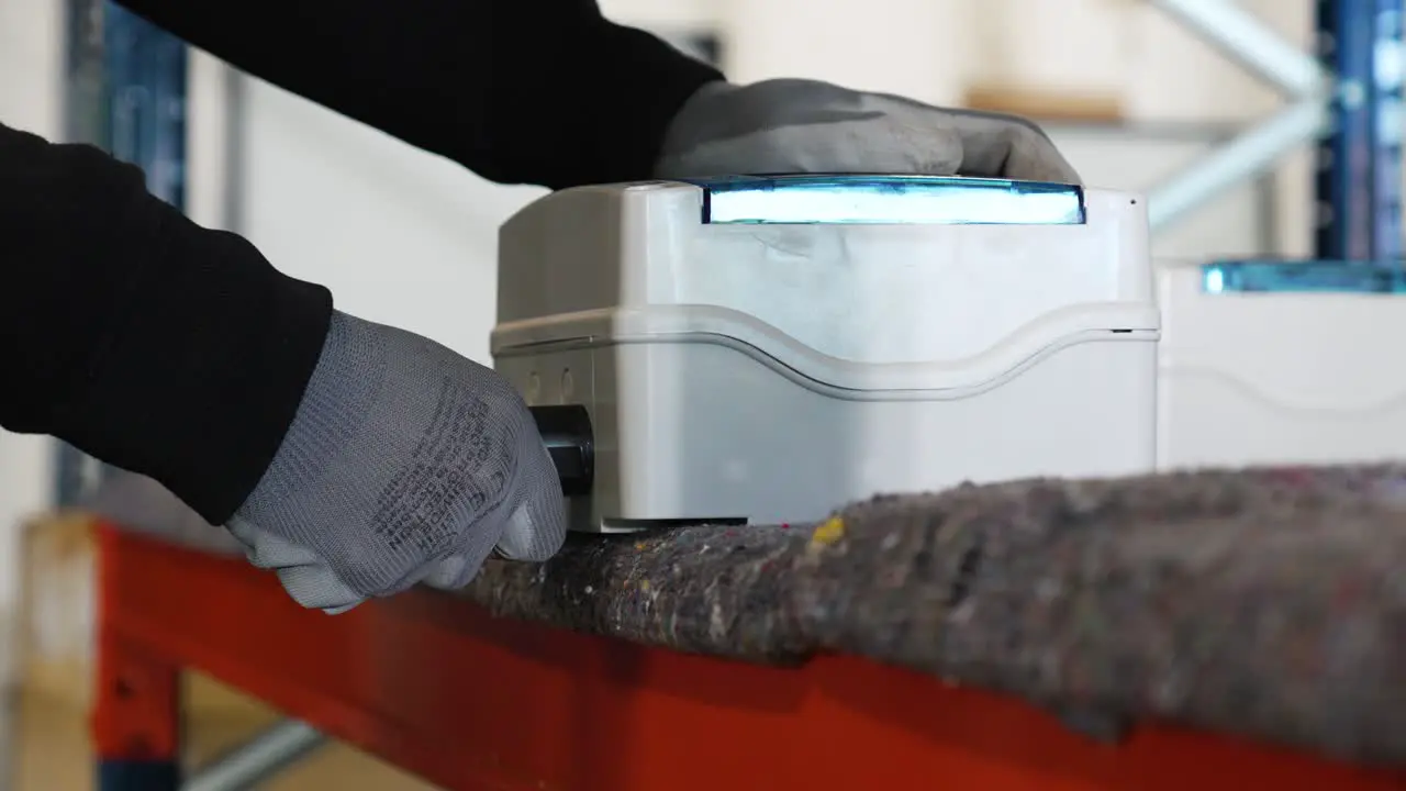 Slowmotion shot of a worker turning a nozzle on an electrical machine on a countertop