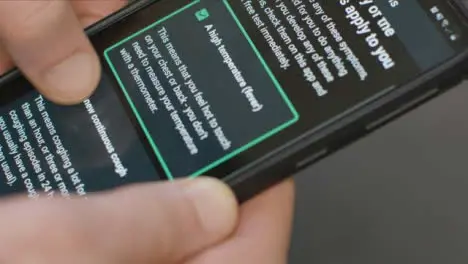 Extreme Close Up of Hands Using COVID Symptom Checker Smartphone App