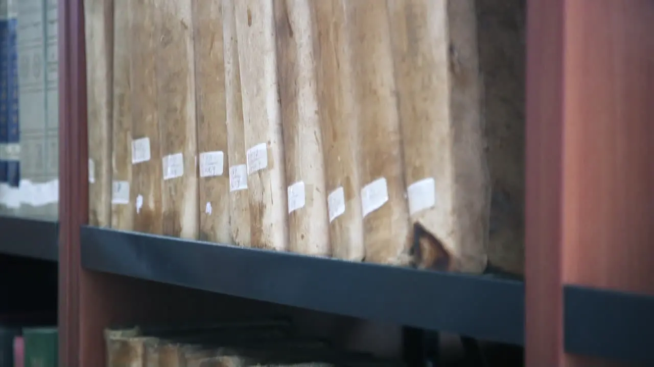 Old books and manuscripts on a wooden shelf in the library