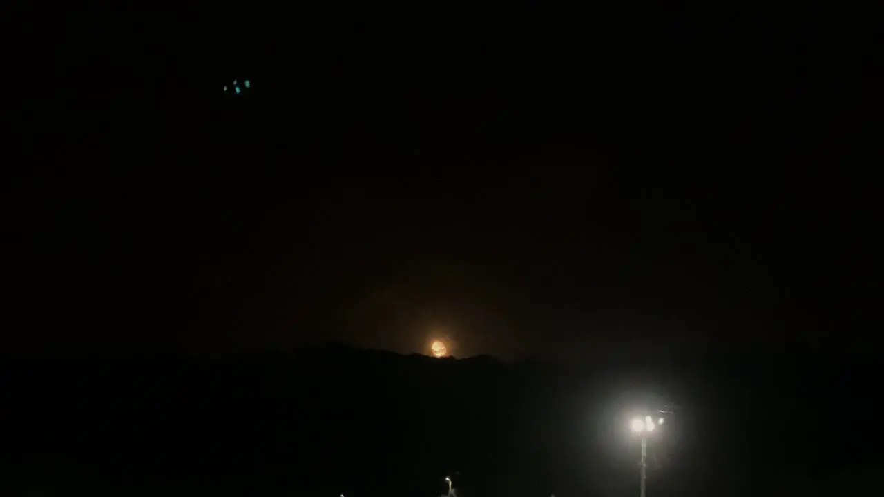 Moon setting behind mountains Setubal Portugal